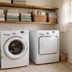 Bright small laundry room with white washer and dryer, wooden open shelves with folded towels and baskets, and a small rug
